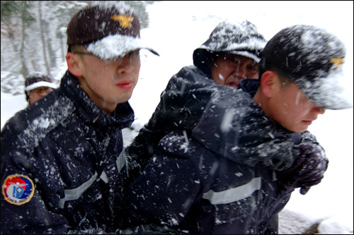 엄청난 폭설이다. 순천 조계산에서 순천 소방서 119구조대원들이 등반 도중 부상당한 환자를 등에 업고 신속하게 산을 내려오고 있다. 